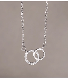 Macro detail of interlocking double rings with pavé cubic zirconia and polished silver finish