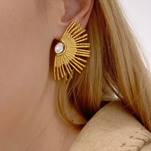 Gold sunflower fan earrings with oval zircon inlay shown on model's ear in close-up