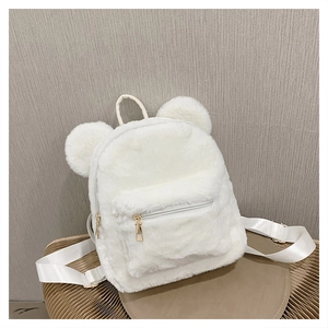 Macro detail of white plush backpack featuring soft faux fur texture and cute 3D bear ears