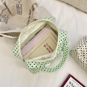 Internal view of a green polka dot canvas toiletry bag showing its large storage capacity