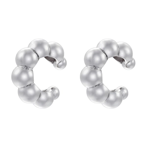Macro view of silver C-shaped bubble ear cuffs with polished metallic finish for women