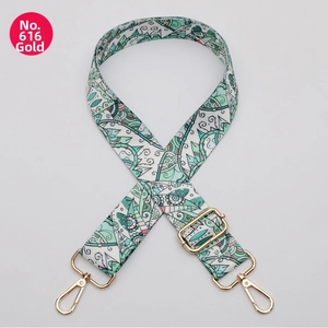 Close-up of green bohemian pattern strap with golden metal clasp and adjuster
