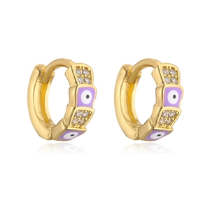 Macro detail of gold-plated hoop earrings with purple enamel eye and sparkling cubic zirconia