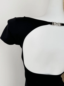 Détail du t-shirt noir dos nu avec une boucle en chaîne métallique argentée élégante