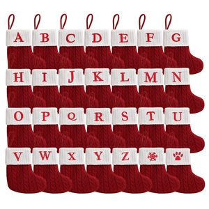 Red knitted Christmas stockings with white cuffs featuring embroidered A-Z letters and paw prints