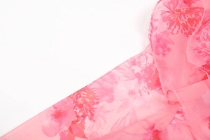 Detail of pink floral print on lightweight chiffon fabric with refined stitching edges