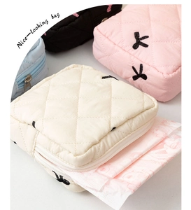 Quilted bow storage pouch detail showing internal space for sanitary pads and zip closure