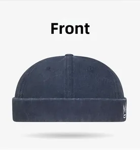 Detail view of navy blue washed cotton docker cap featuring white crown embroidery