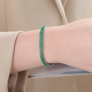 Close-up of elegant tennis bracelet featuring rectangular green zircon stones in silver setting