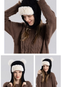 Close-up of winter plush trapper hat with fluffy pom-poms and faux lamb wool lining