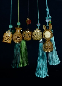 Macro detail of hand-carved sandalwood sachet pendant with elegant silk tassels