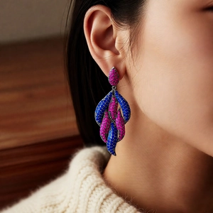 Close-up of vintage teardrop earrings with blue and rose rhinestones on a female model