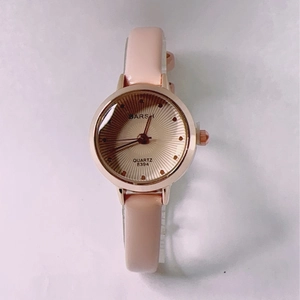 Macro detail of rectangular rose gold watch face with pink leather strap