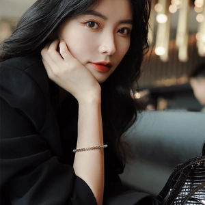 Elegant rose gold minimalist thin geometric bangle bracelet worn by model in black outfit