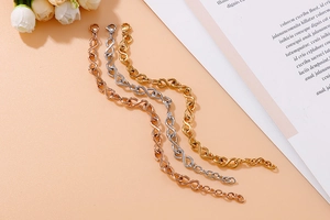 Macro shot of stainless steel infinity link bracelets in gold, silver and rose gold