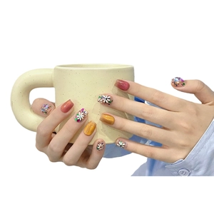 Faux ongles faits main avec motifs floraux et effet œil de chat scintillant corail et rouge
