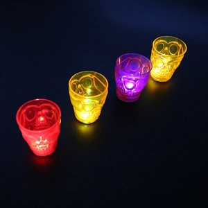 Set of four LED glowing skull shot glasses in red, yellow, purple and orange colors