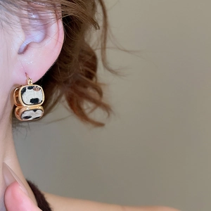 Dettaglio della modella con orecchini quadrati placcati oro 18K con motivo a macchie bianco e nero
