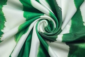 Macro shot of high-quality silk fabric with green and white abstract ink print pattern
