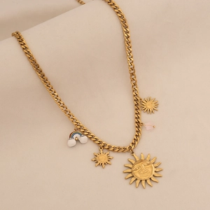 Dettaglio della collana a catena dorata con ciondoli a forma di sole e arcobaleno