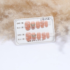 Elegant nude press-on nails with 3D rhinestone bows and pearls for women