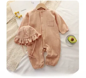 Detail of khaki cotton gauze baby romper and matching ruffle hat on soft fabric