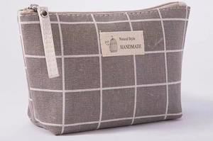 Macro shot of grey plaid canvas makeup bag with Natural Style handmade fabric label