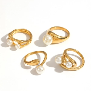 Set of four French retro gold titanium steel rings with elegant faux pearls on white background