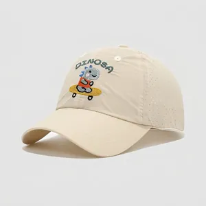 Detail of embroidered skateboarding dinosaur on breathable beige cotton kids baseball cap