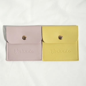 Detail of lavender and ginger yellow PU leather jewelry pouches with gold metal snap buttons