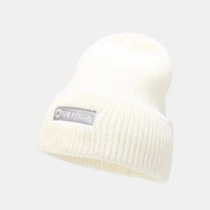 Detailed texture of white ribbed knit beanie with THE FOCUS embroidered gray woven label