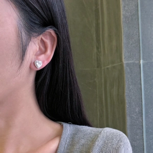 Close-up of S925 silver heart stud earrings with cubic zirconia on a female model