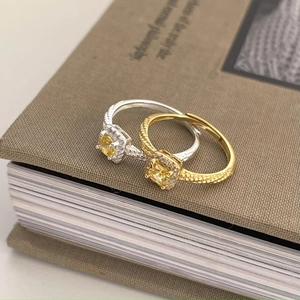 Adjustable 925 silver and gold twist rings with square yellow diamonds on vintage book
