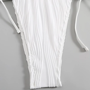 Dettaglio dello slip bikini bianco a coste con lacci laterali e texture verticale