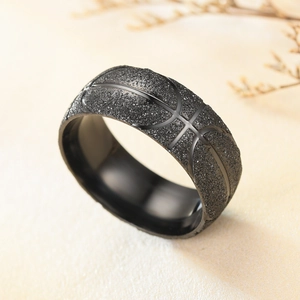Primer plano de anillo deportivo negro de acero con textura de basket y acabado mate