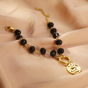 Macro detail of retro black crystal beads and golden MAMA pendant on silk