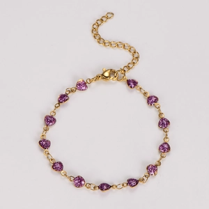 Detail of gold chain bracelet with multiple purple glitter heart charms and lobster clasp