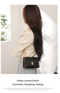 Close-up of black crossbody bag with red edges, gold studs, and metallic chain strap
