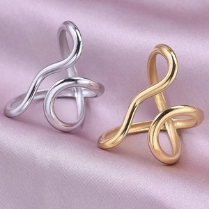 Polished silver and gold minimalist wavy rings on elegant lavender silk fabric