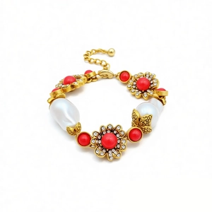 Vintage gold necklace with red beads, pearls, and crystals on a clean white background