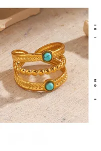 Détail d'une bague bohème triple couche dorée avec pierre turquoise et textures
