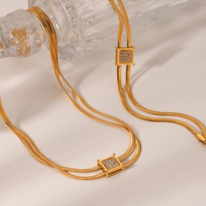 Detail of gold double-layer snake chain and square pendant with micro-set zircons