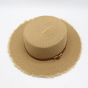 Détail d'un chapeau de paille aux bords effilochés et ruban en cuir avec boucle dorée