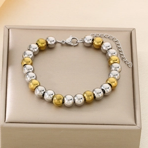 Close-up of gold and silver beaded stainless steel bracelet with lobster clasp and chain