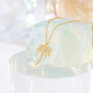 Macro view of gold S925 silver palm tree pendant with sparkling white zircons