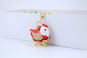 Detail of red and white hen keychain with gold metal plating and sparkling rhinestones