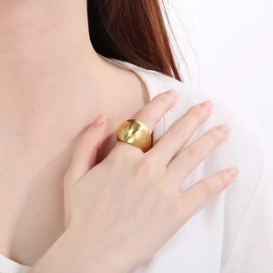 Polished gold wide band stainless steel ring with brushed finish shown on a model