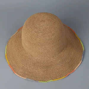 Detailed close-up of handmade straw hat featuring colorful crochet rainbow rim design