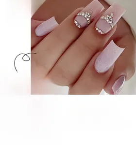 Detailed view of long square press-on nails with pink glitter and rhinestone accents