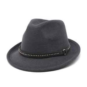 Detail of dark grey fedora hat with metal rivets and a golden buckle on the black band